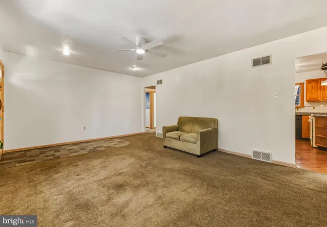 a living room with furniture and a ceiling fan
