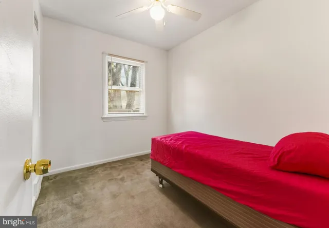 a room with a bed and a chandelier fan