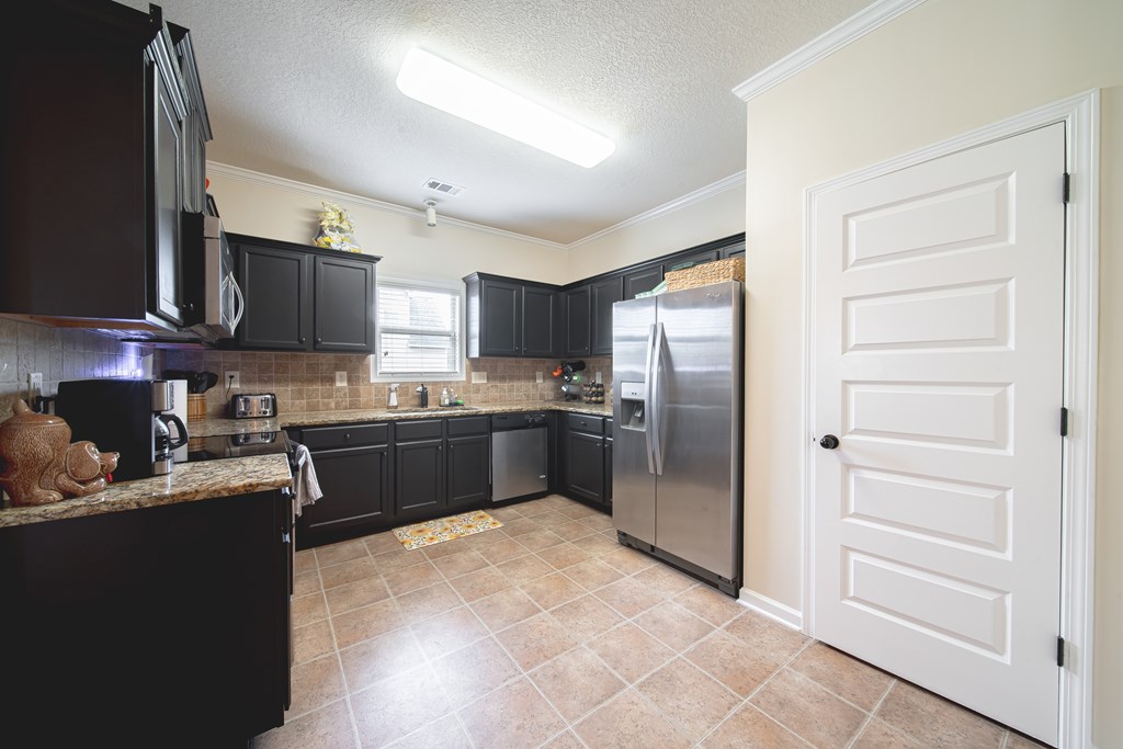 305 Owens Road Fort Mitchell, AL 36856 - Photo 12 of 44 a kitchen with granite countertop stainless steel appliances and counter space