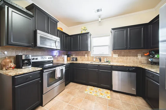 a kitchen with stainless steel appliances granite countertop a sink stove and refrigerator