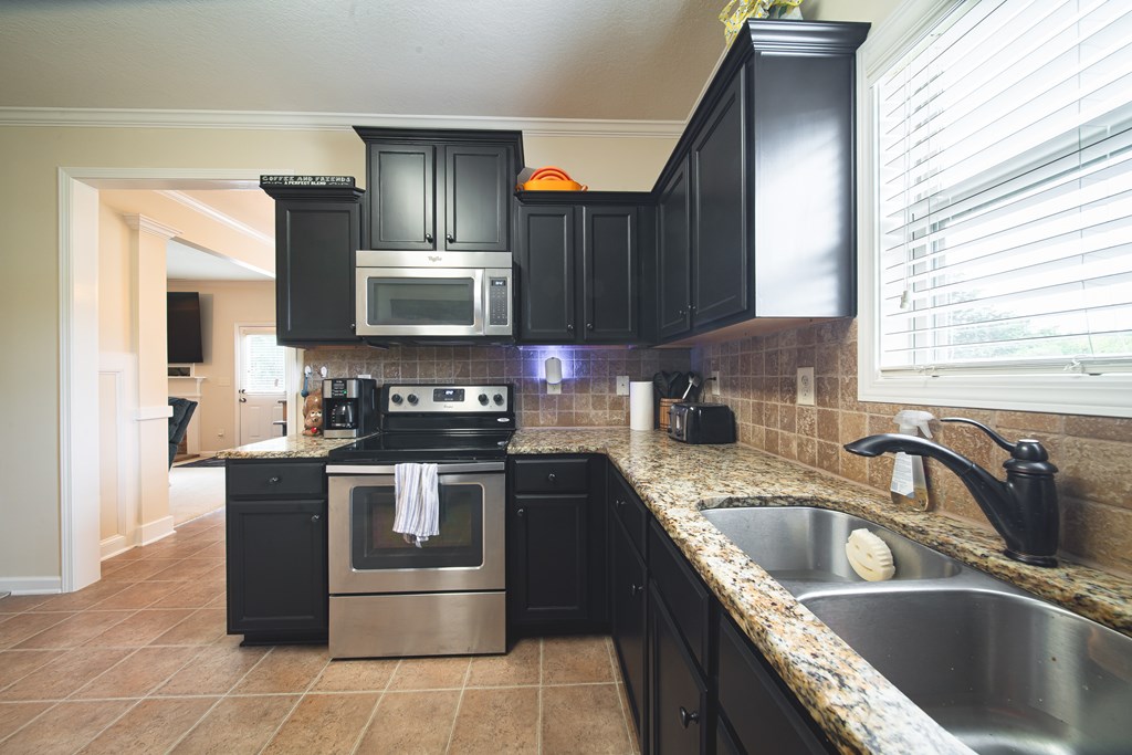 305 Owens Road Fort Mitchell, AL 36856 - Photo 14 of 44 a kitchen with stainless steel appliances granite countertop a sink stove and refrigerator