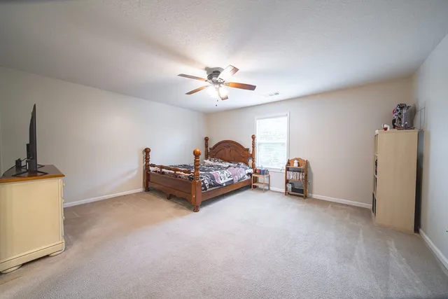a spacious bedroom with a bed and a chandelier