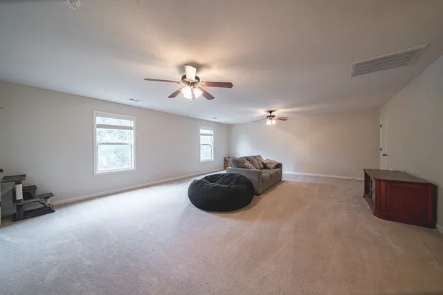 a living room with furniture and a ceiling fan