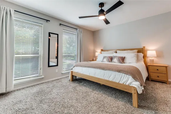 a bedroom with a large bed and a chandelier fan