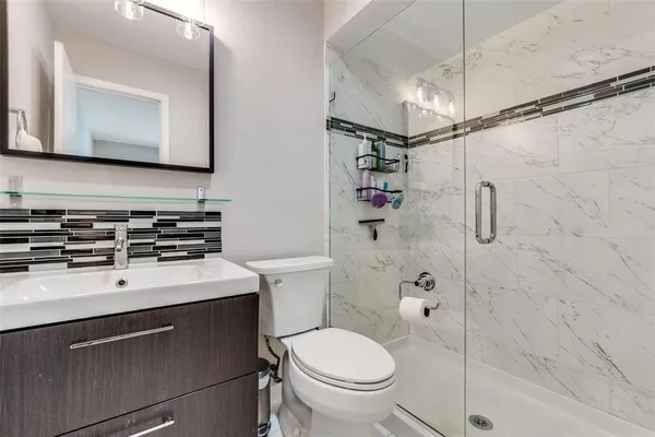 a bathroom with a sink toilet mirror and shower