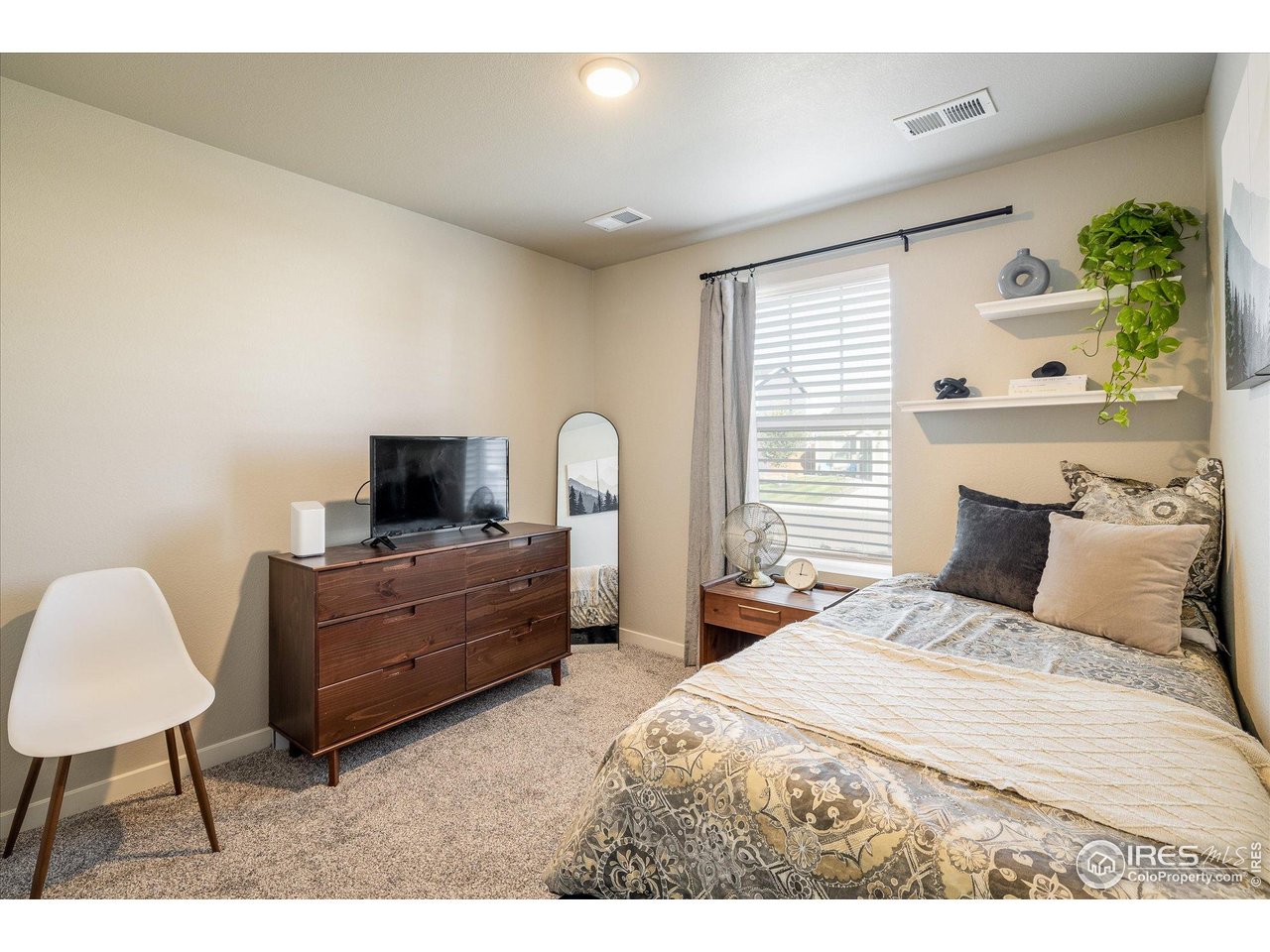 735 South Hoover Avenue Fort Lupton, CO 80621 - Photo 15 of 21 a bedroom with a bed and a chair
