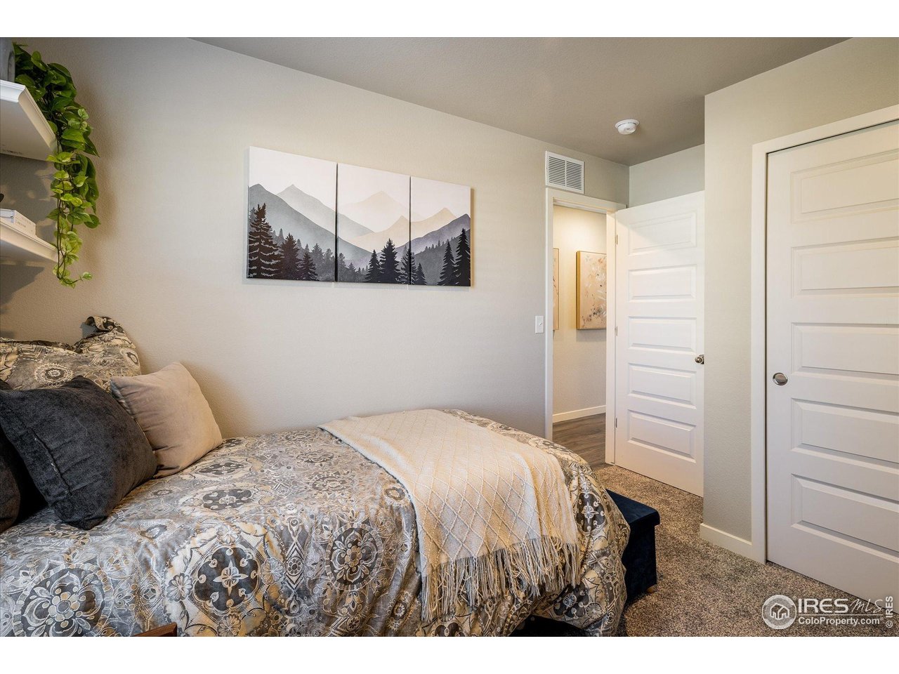 735 South Hoover Avenue Fort Lupton, CO 80621 - Photo 16 of 21 a bedroom with a bed and a painting on the wall