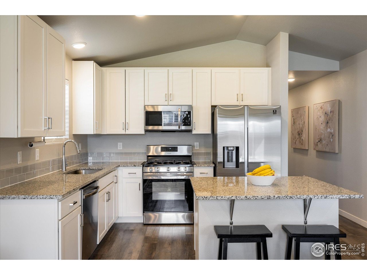 735 South Hoover Avenue Fort Lupton, CO 80621 - Photo 5 of 21 a kitchen with stainless steel appliances a sink a stove a refrigerator cabinets and a dining table