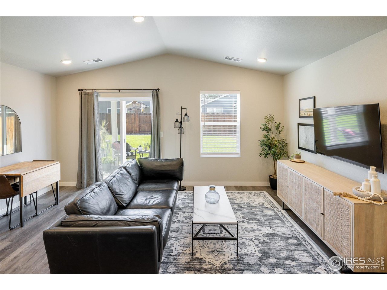 735 South Hoover Avenue Fort Lupton, CO 80621 - Photo 8 of 21 a living room with furniture and a flat screen tv