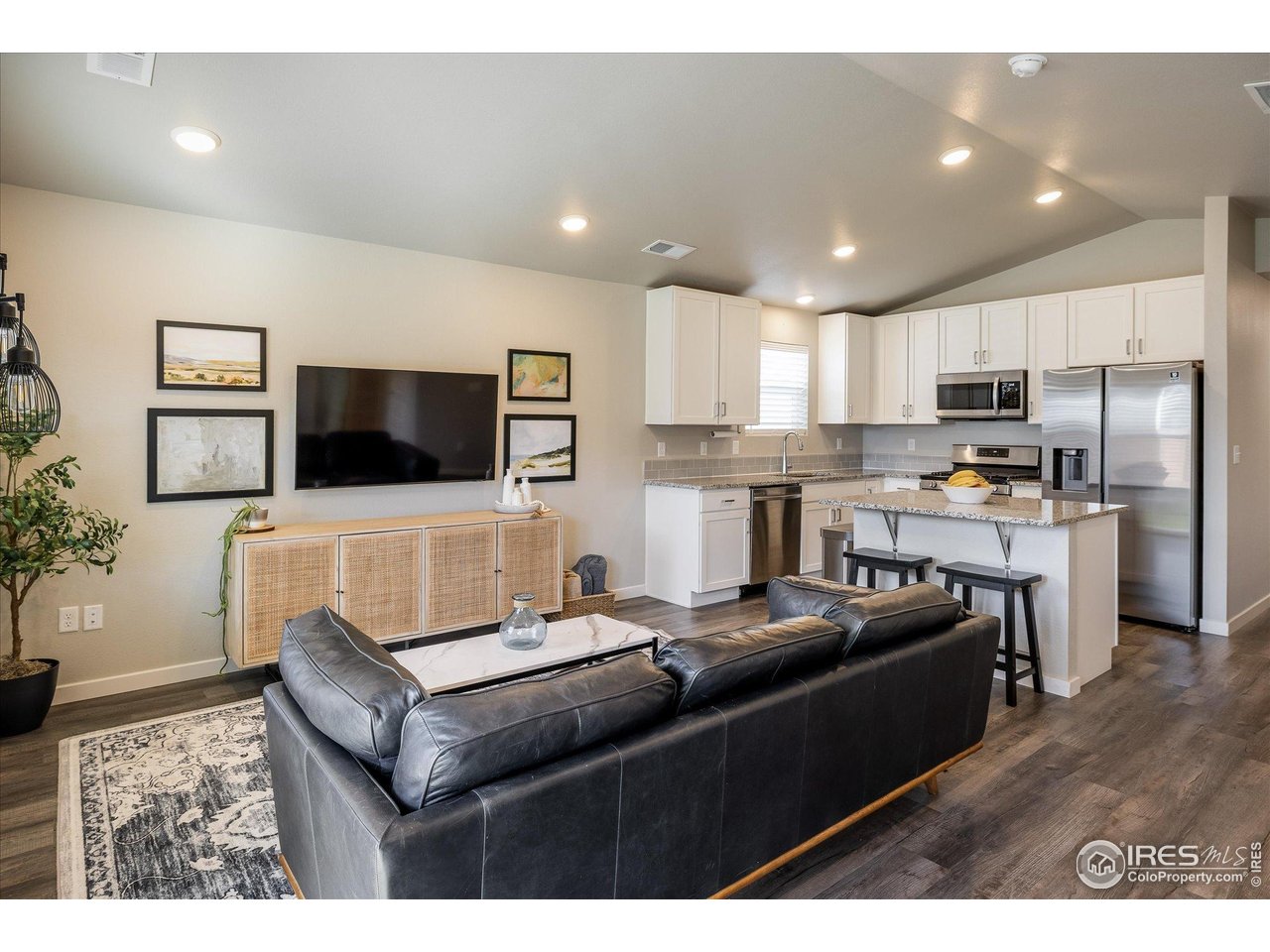 735 South Hoover Avenue Fort Lupton, CO 80621 - Photo 9 of 21 a living room with stainless steel appliances kitchen island granite countertop a stove a sink a refrigerator and a refrigerator