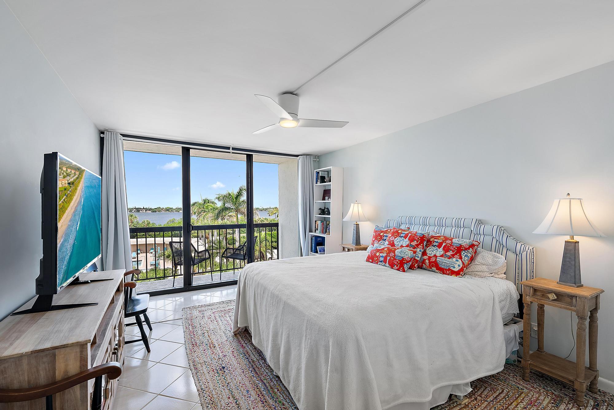 3390 South Ocean Boulevard, Unit 301 Palm Beach, FL 33480 - Photo 23 of 46 a bedroom with a balcony a bed and a flat screen tv