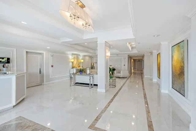 a lobby with furniture and a chandelier