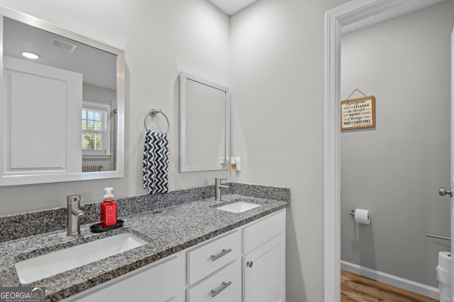 192 Hummingbird Lane Jesup, GA 31545 - Photo 16 of 26 a bathroom with a granite countertop sink and a mirror