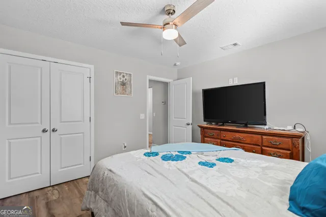 a bedroom with a bed and a flat screen tv