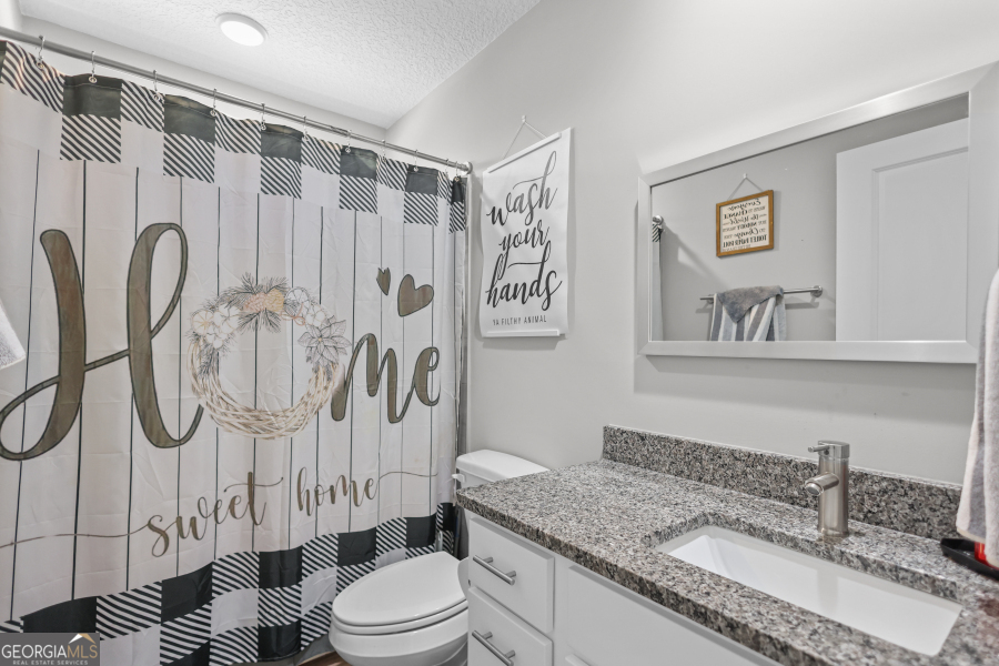 192 Hummingbird Lane Jesup, GA 31545 - Photo 20 of 26 a bathroom with a granite countertop sink and a mirror