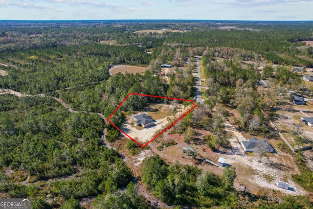 an aerial view of a houses with a yard