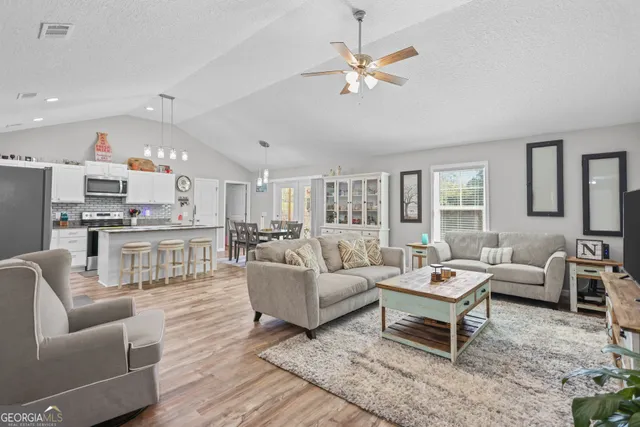 a living room with furniture and view of kitchen