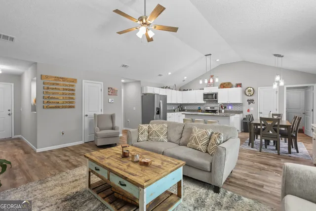 a living room with furniture and kitchen view