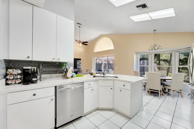 a kitchen with white cabinets and sink