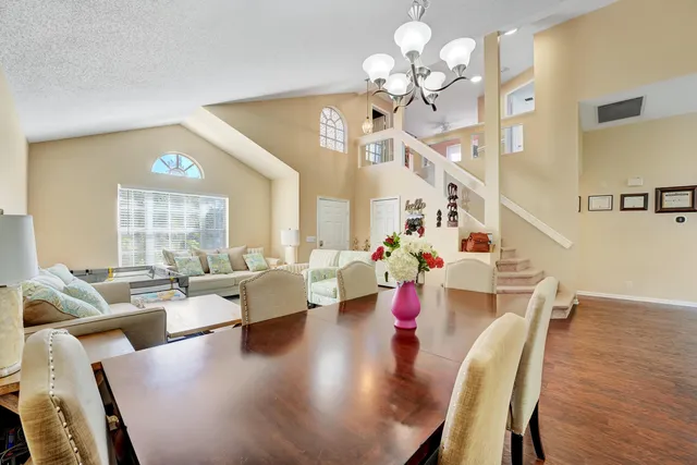 a view of a dining room with furniture a chandelier and wooden floor