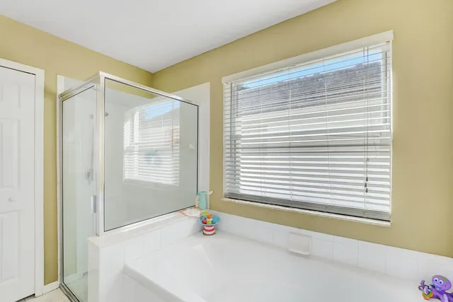 a bathroom with a bathtub and next to a window