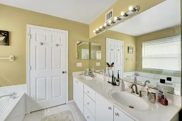 a bathroom with a double vanity sink a mirror and a shower