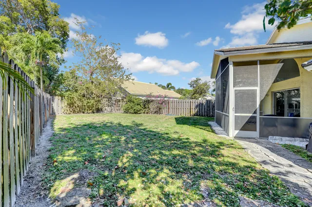 a view of backyard with potted plants and wooden fence
