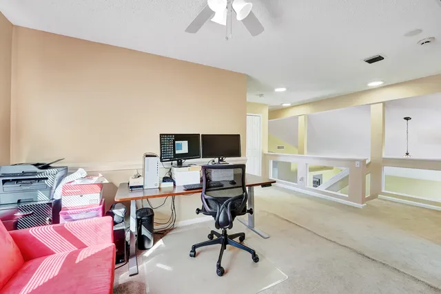 a view of a workspace with furniture and a window