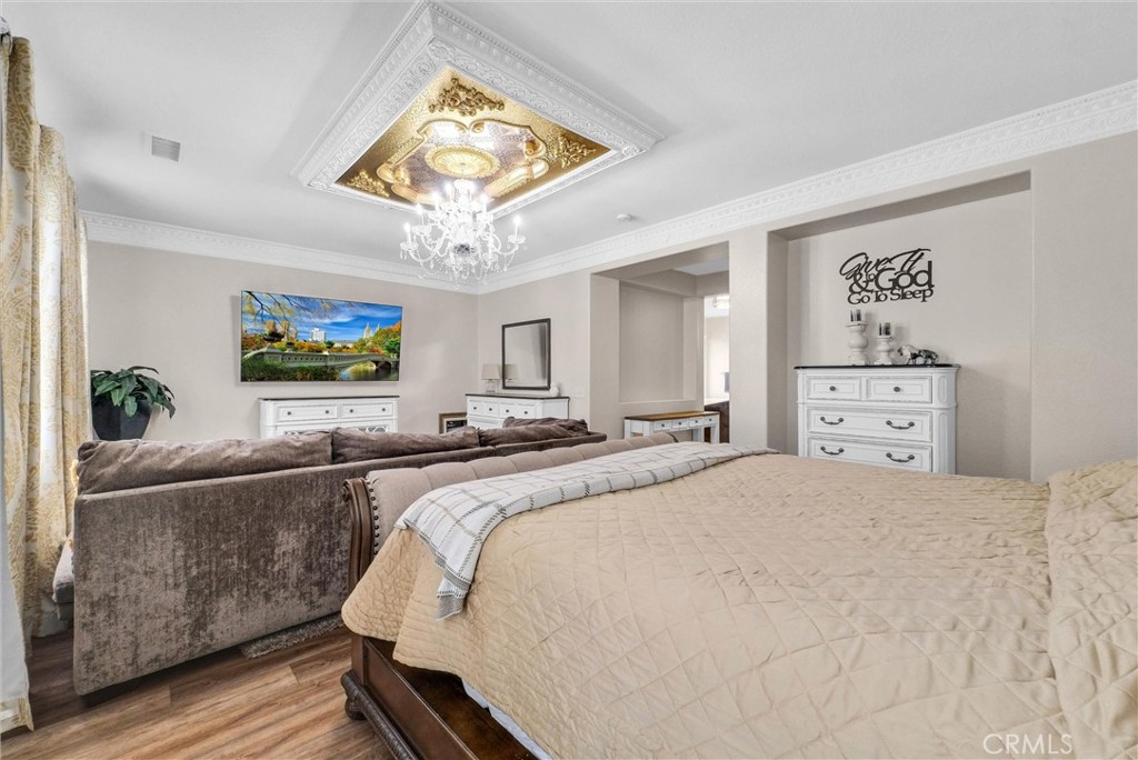 11499 Bridgeway Drive Riverside, CA 92505 - Photo 40 of 70 a spacious bedroom with a bed and a chandelier