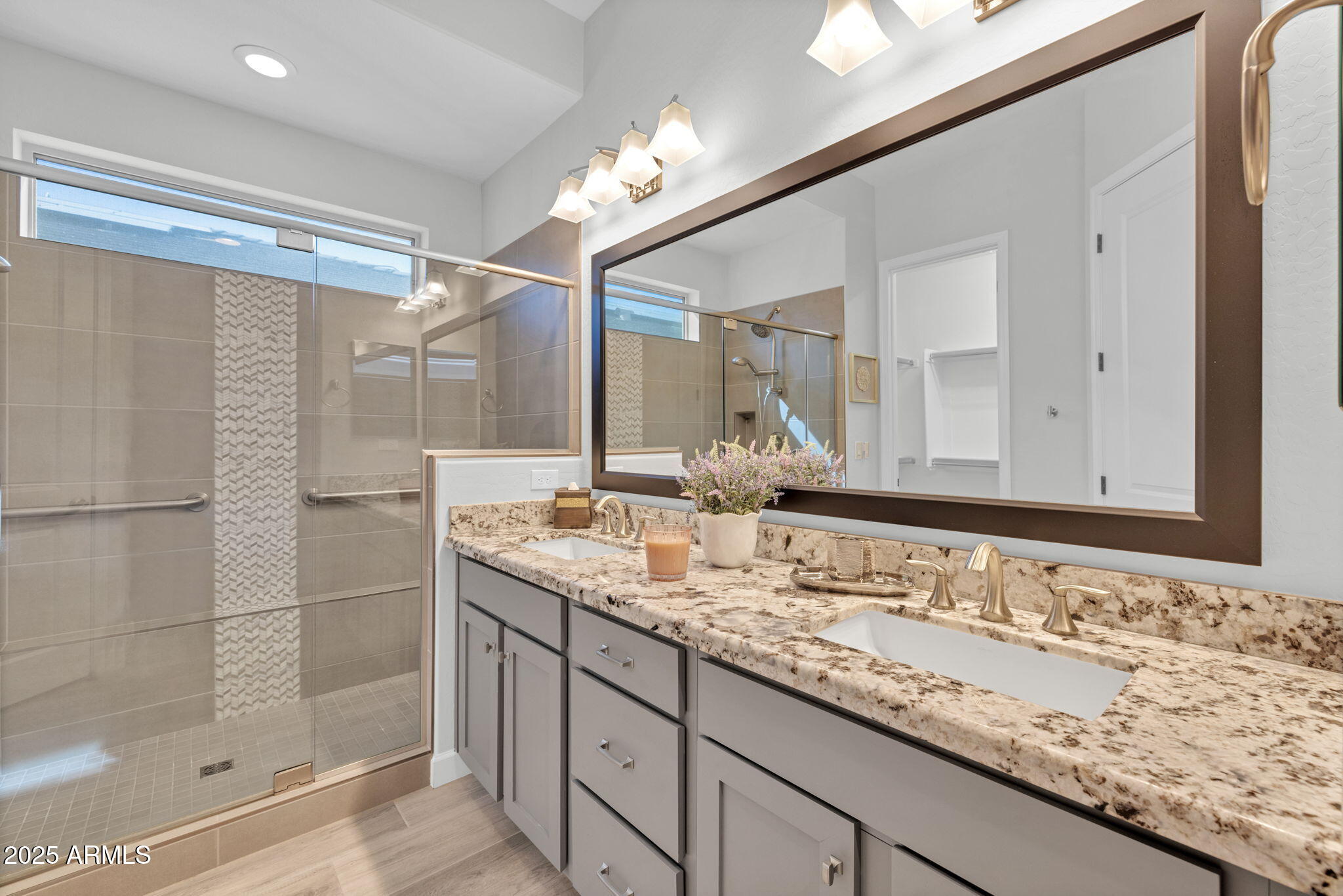 13189 West Caleb Road Peoria, AZ 85383 - Photo 23 of 70 a bathroom with a granite countertop sink a mirror and shower