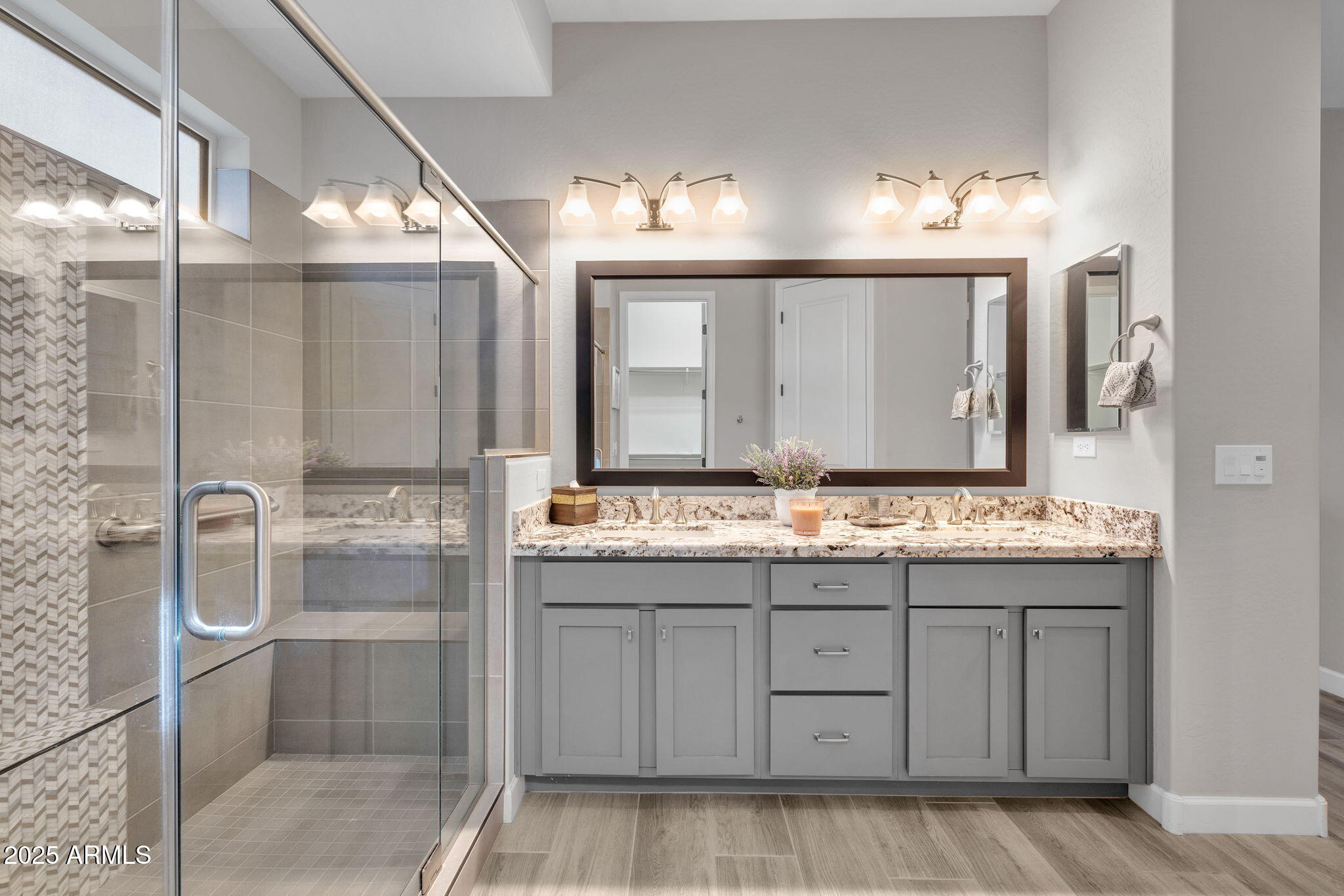 13189 West Caleb Road Peoria, AZ 85383 - Photo 24 of 70 a bathroom with a granite countertop sink a mirror and a shower