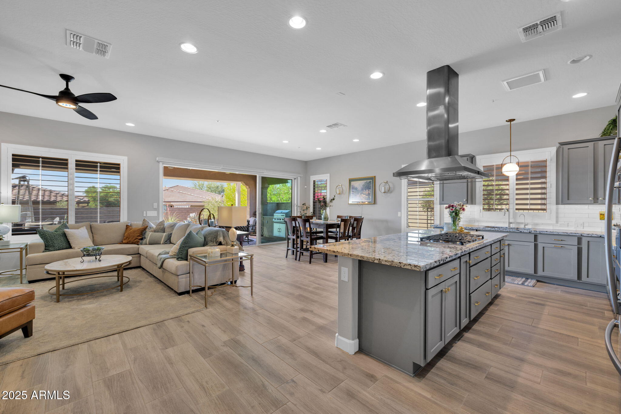 13189 West Caleb Road Peoria, AZ 85383 - Photo 3 of 70 a large kitchen with stainless steel appliances kitchen island granite countertop a large counter top a stove and a wooden floors