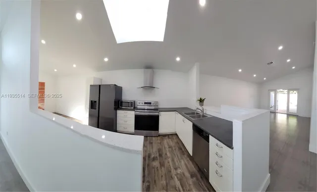 a kitchen with stainless steel appliances kitchen island sink stove and refrigerator