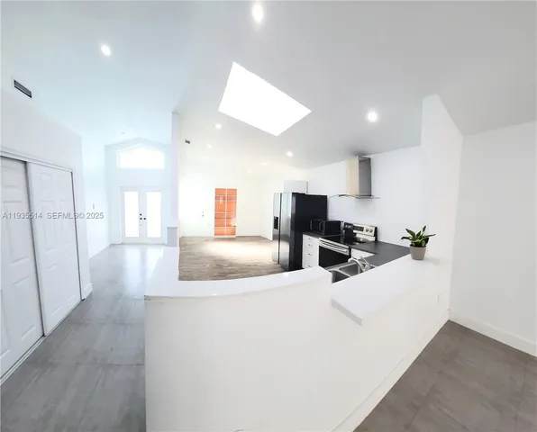 a view of kitchen with refrigerator sink and wooden floor