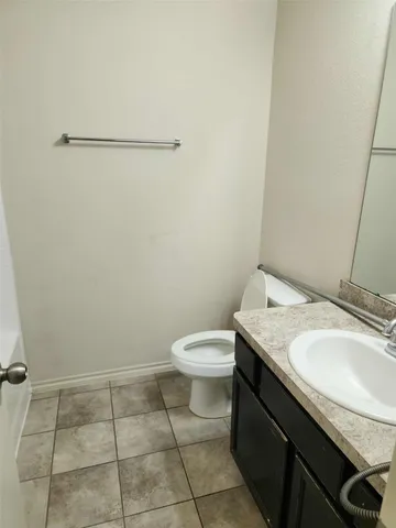 a bathroom with a granite countertop sink and a toilet
