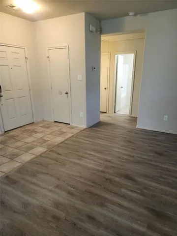 a view of an empty room with wooden floor