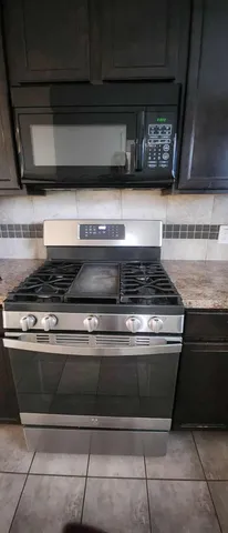 a stove top oven sitting inside of a kitchen