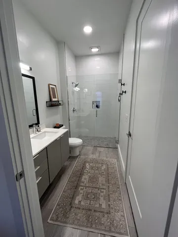 a bathroom with a sink a toilet and shower