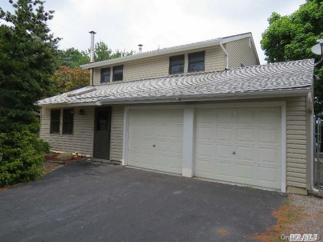 54 Rustic Avenue Medford, NY 11763 - Photo 1 of 1 a front view of a house with garage