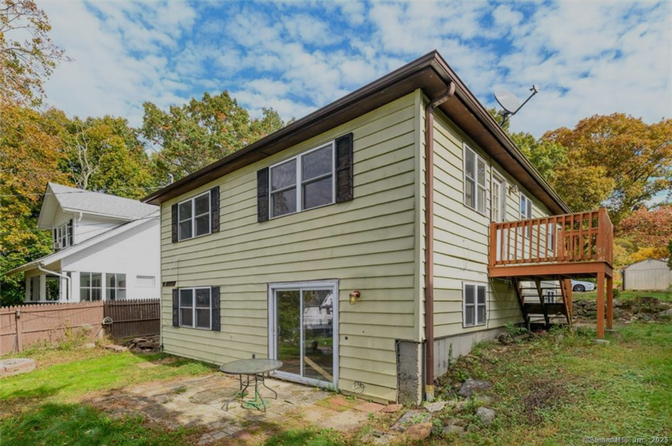 a view of house with a yard and sitting area