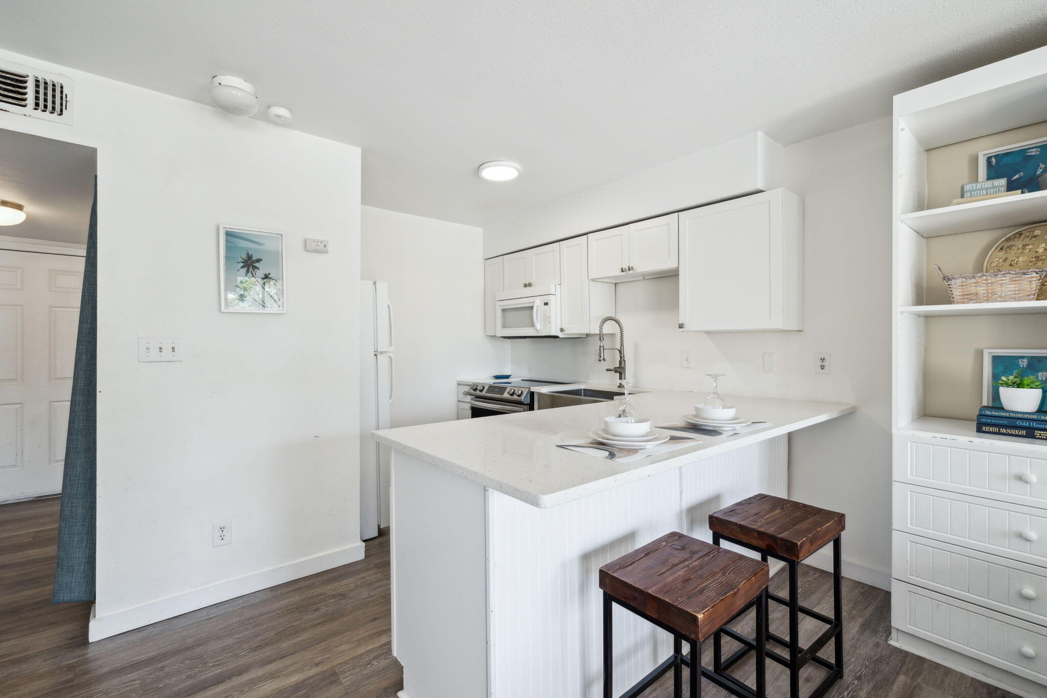 145 Beachfront Trail, Unit 102A Santa Rosa Beach, FL 32459 - Photo 12 of 33 a kitchen with a sink a stove a refrigerator and white cabinets with wooden floor