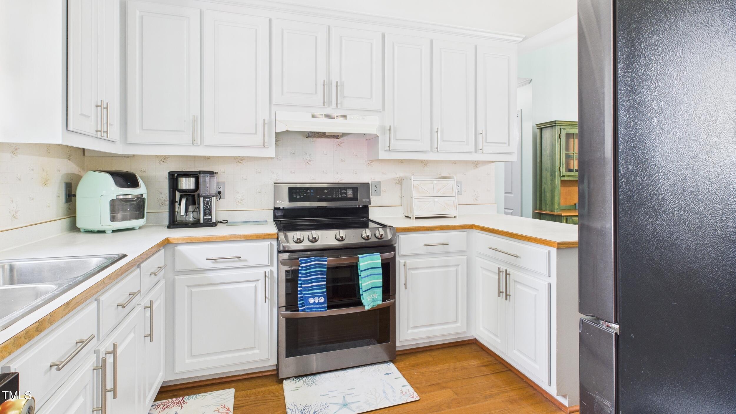 5309 Meadow Field Drive Mebane, NC 27302 - Photo 11 of 41 a kitchen with stainless steel appliances granite countertop a stove and a white cabinets