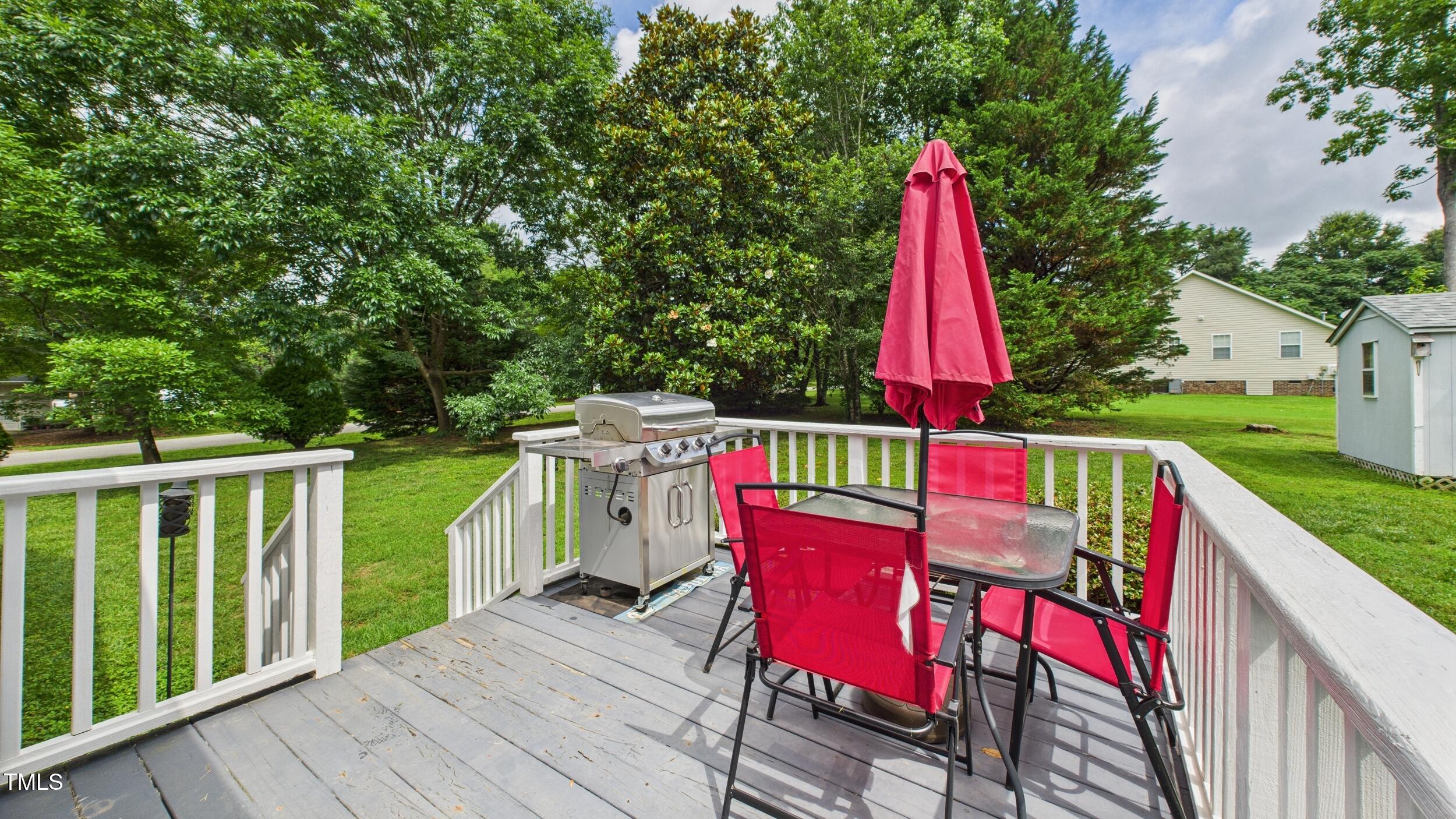 5309 Meadow Field Drive Mebane, NC 27302 - Photo 23 of 41 a view of a deck with a table and chairs a barbeque with wooden floor and fence