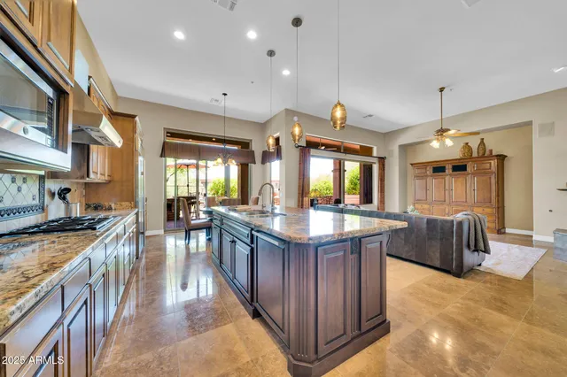 a kitchen with stainless steel appliances granite countertop table chairs sink and cabinets