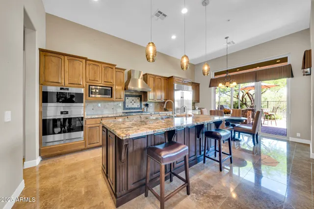 a kitchen with granite countertop a sink counter space stainless steel appliances and cabinets