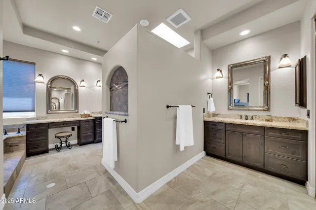 a bathroom with a granite countertop sink a toilet a mirror and vanity