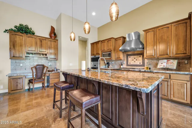 a kitchen with granite countertop a table chairs sink and cabinets