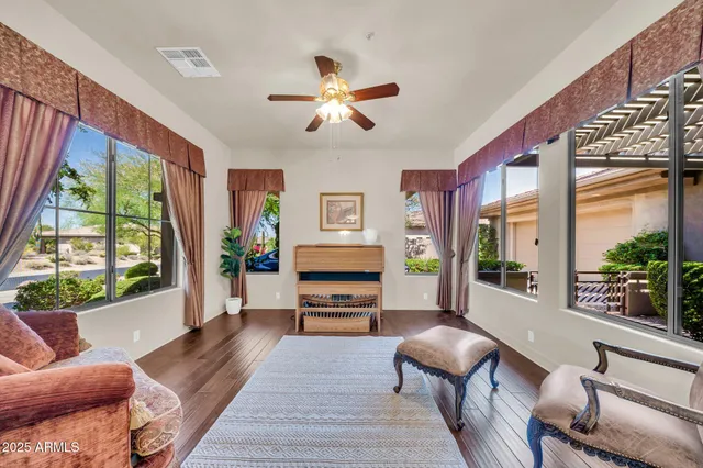 a living room with furniture a flat screen tv and a large window