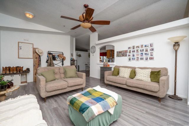 a living room with furniture ceiling fan and a wooden floor
