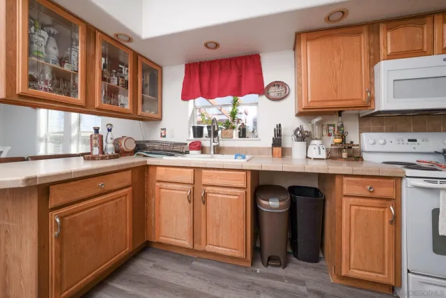 a kitchen with stainless steel appliances granite countertop a sink dishwasher stove and cabinets with wooden floor